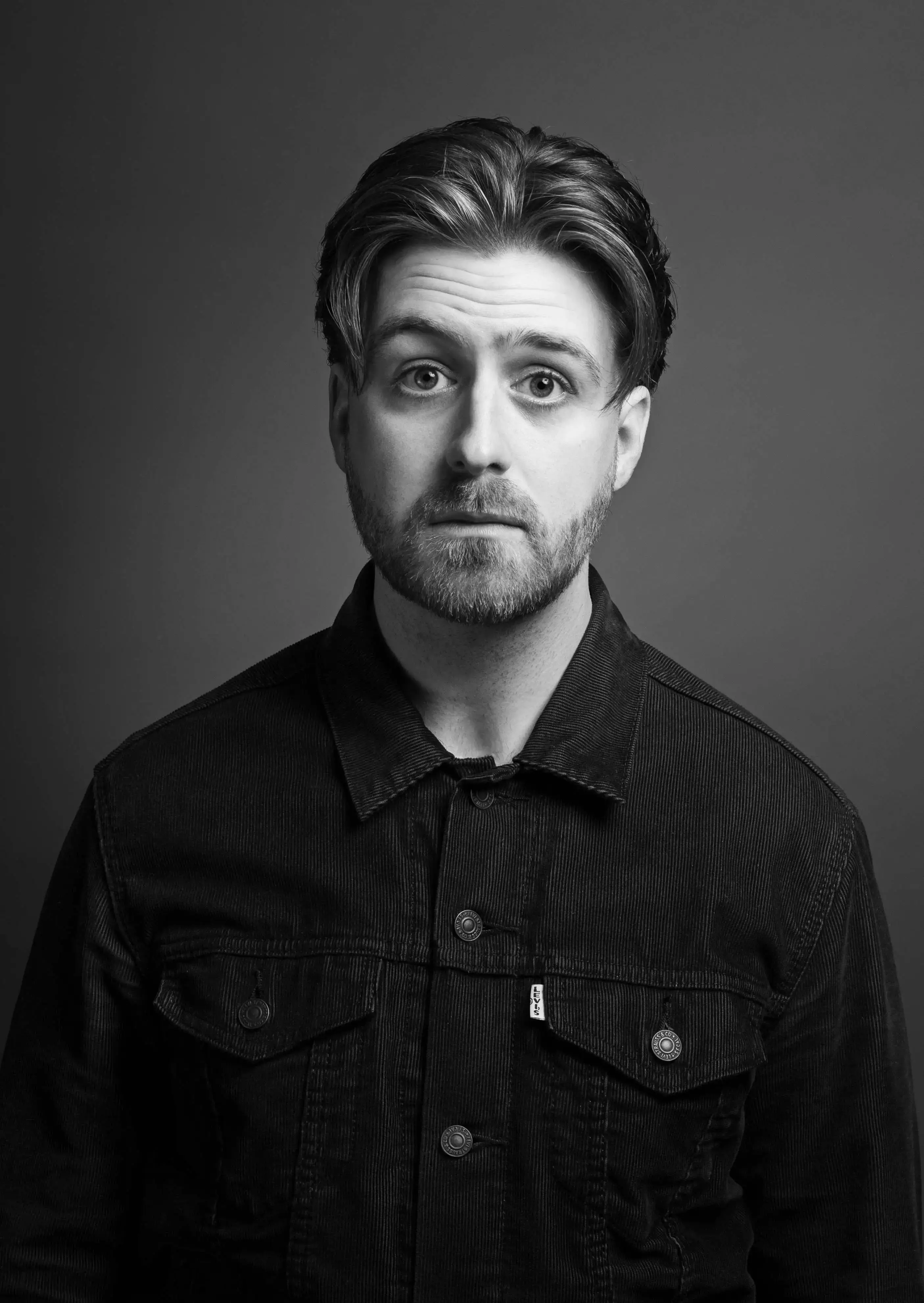 Man with curtain style haircut with beard and denim jacket