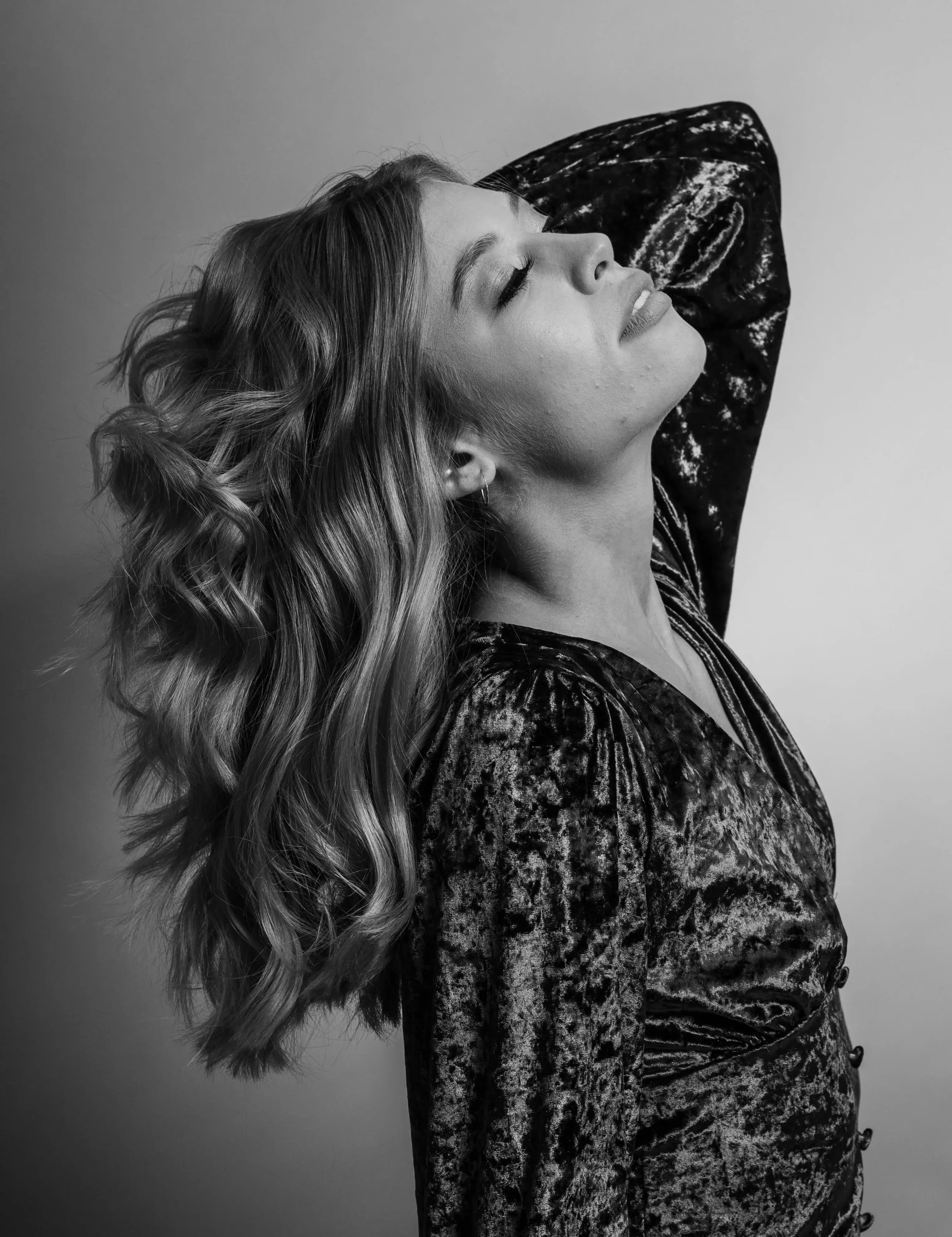 Woman with medium length wavy hair looking upwards