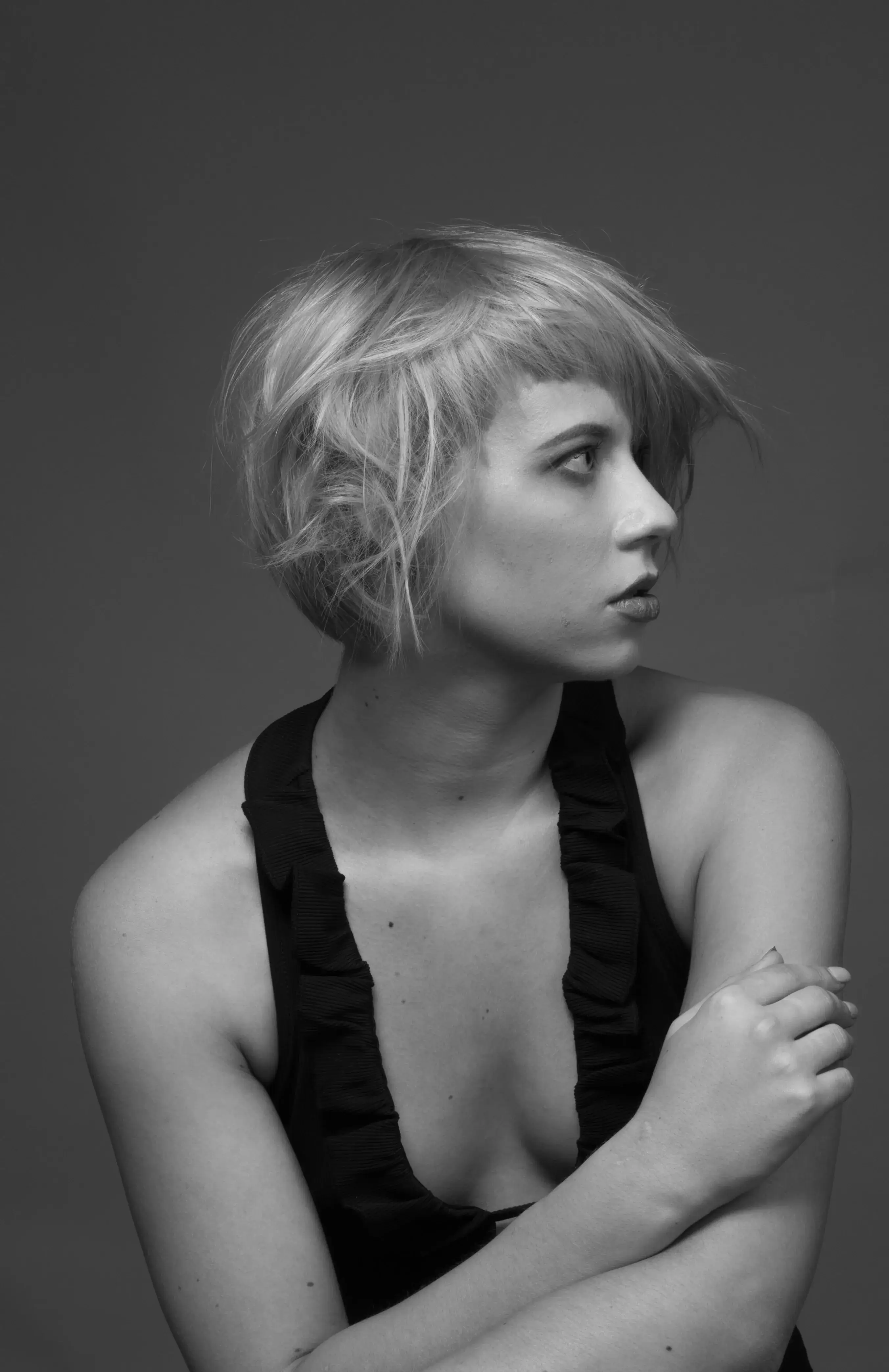 Woman with messy straight hair looking to the right in black and white