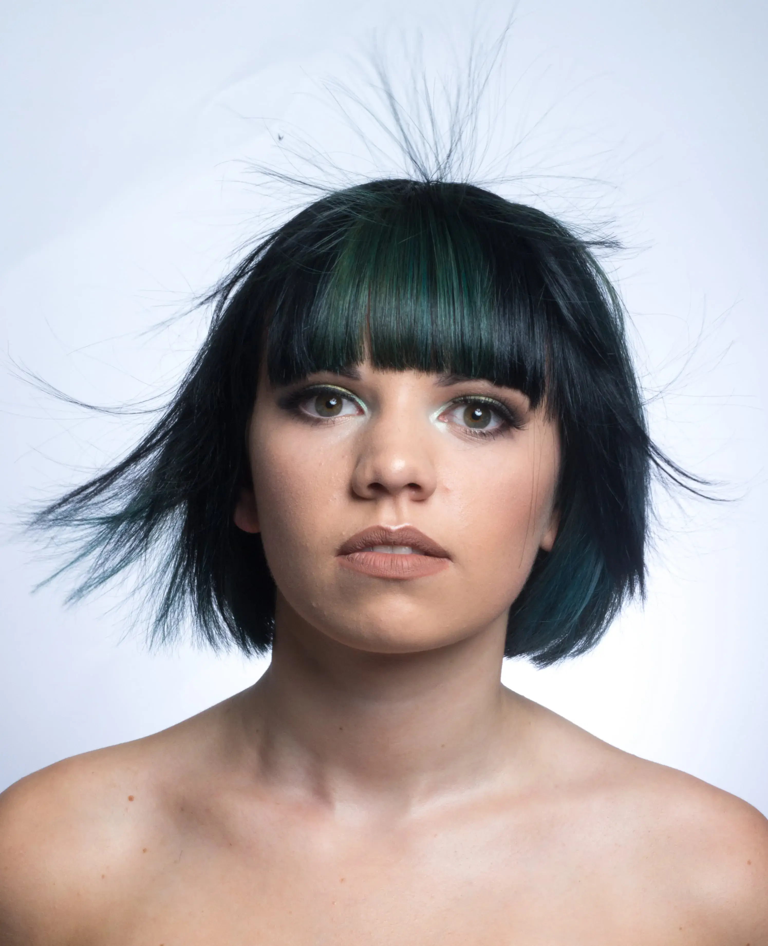 Woman with a mixture of blue and green hair in a bob cut with full fringe